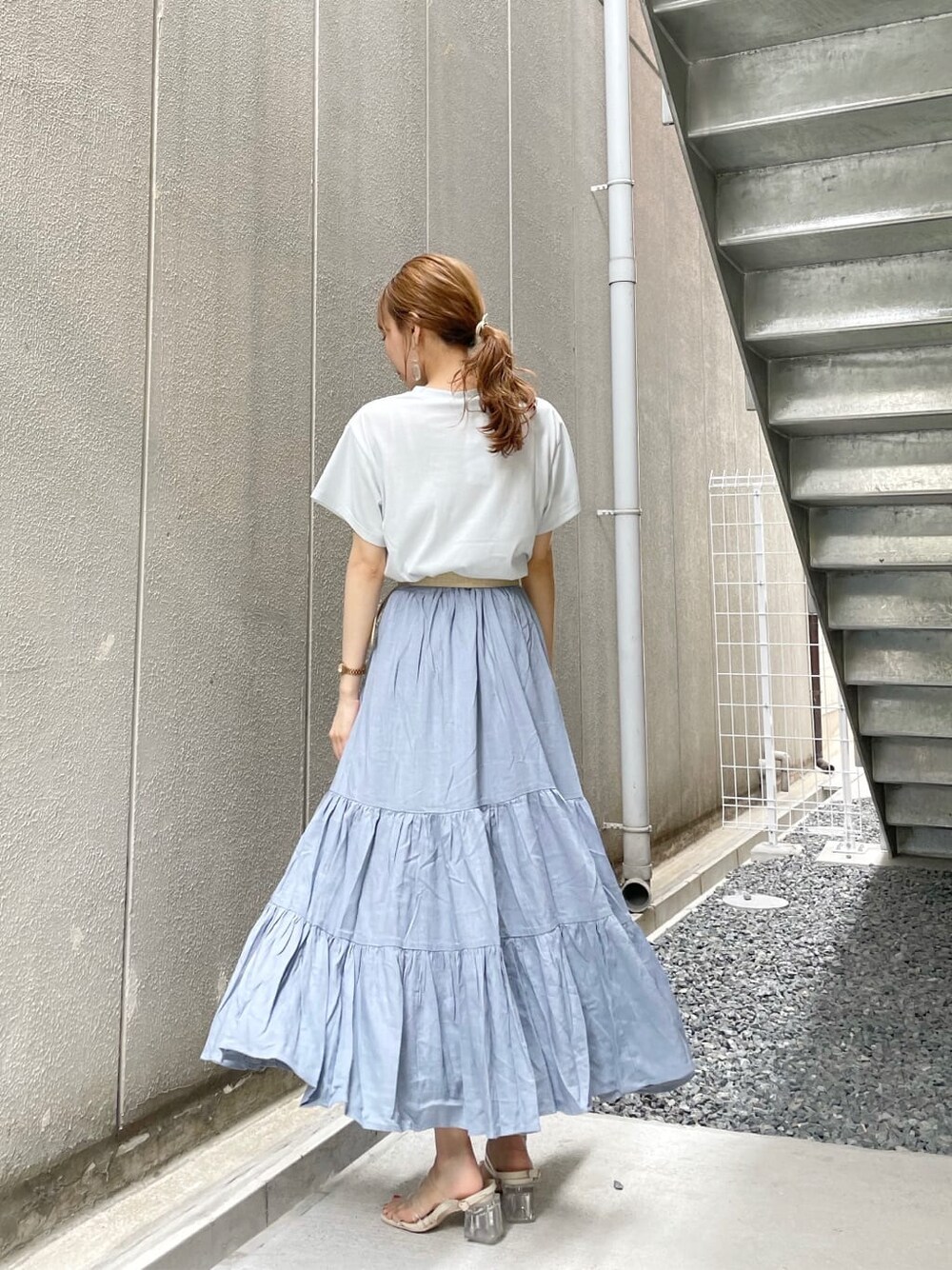 ブルー系のスカート、その他のサンダル、ブルー系のTシャツ/カットソーを着用したレディースの夏コーディネートの3枚目の写真