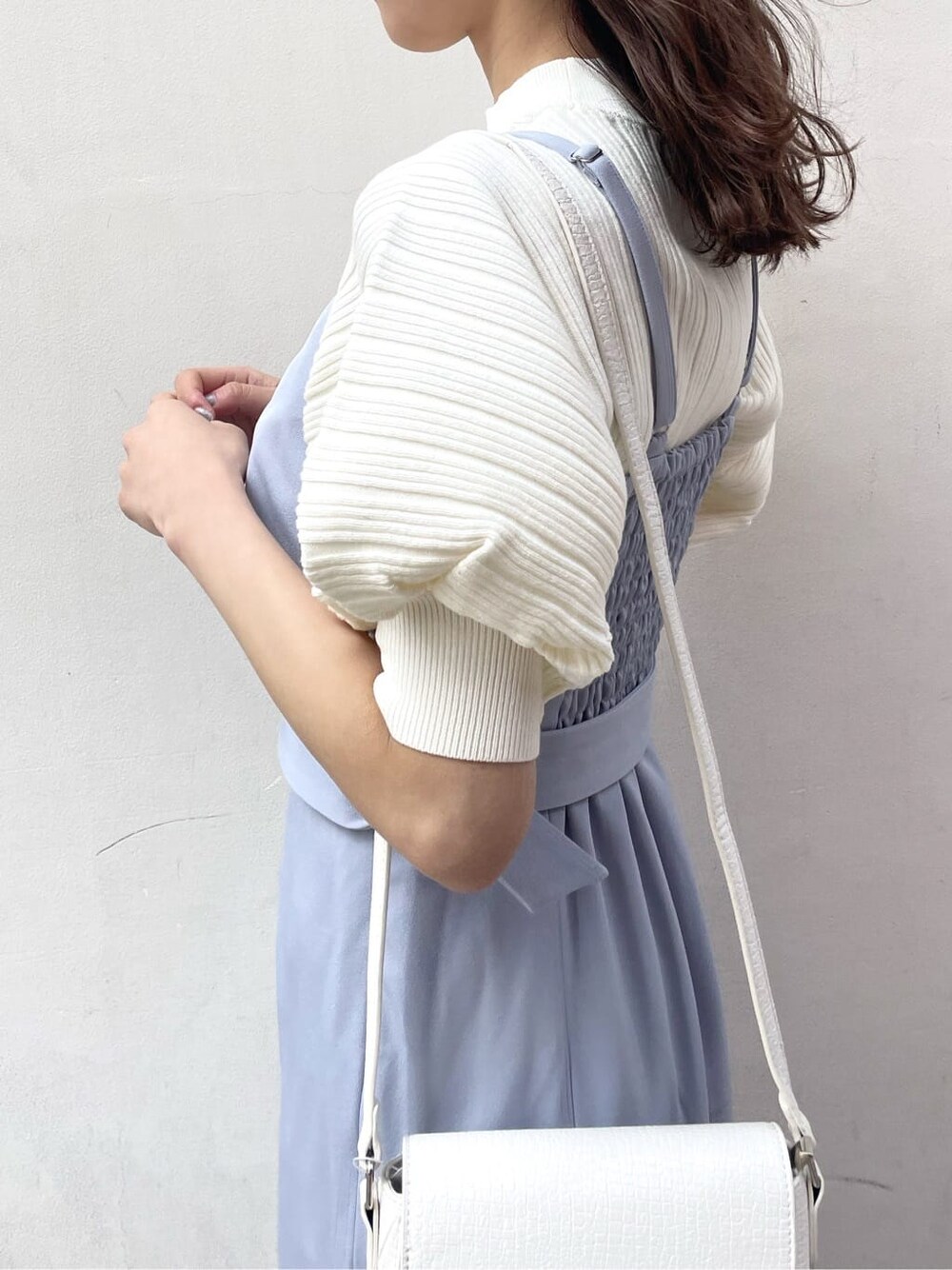 ブルー系のワンピース、ホワイト系のニット/セーター、ホワイト系のパンプスを着用したレディースの春コーディネートの5枚目の写真