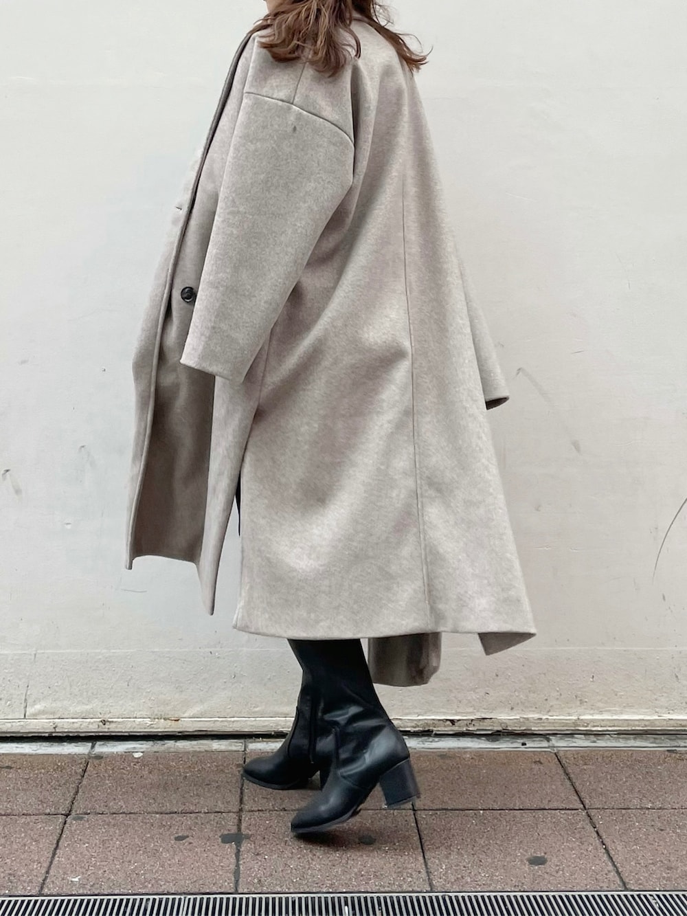 ブルー系のデニムパンツ、ブラック系のブーツ、グレー系のニット/セーターを着用したレディースの冬コーディネートの6枚目の写真