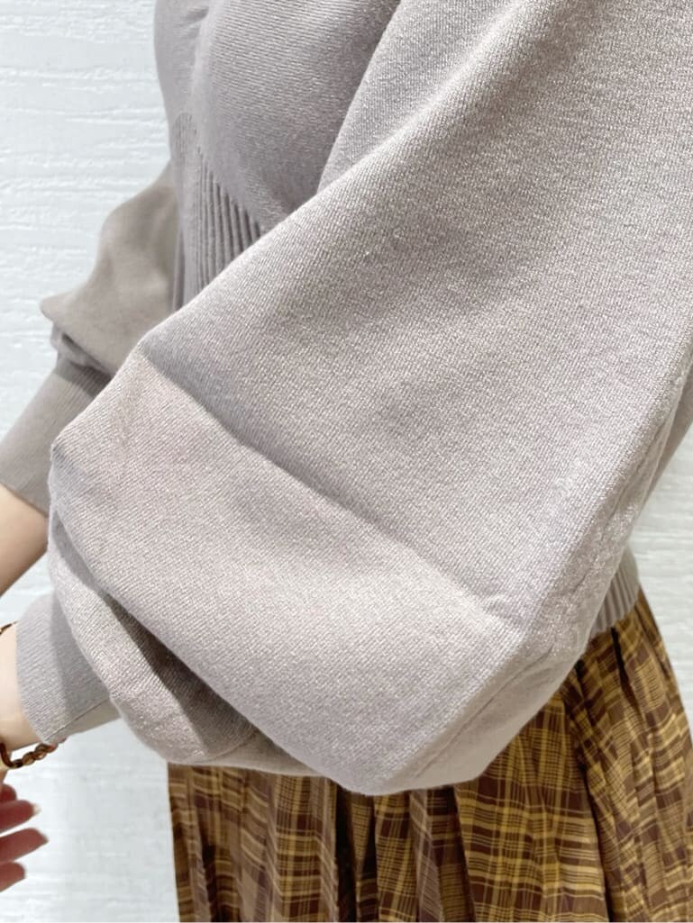 ブラウン系のスカート、ベージュ系のTシャツ/カットソー、ブラック系のブーツを着用したレディースの秋コーディネートの9枚目の写真