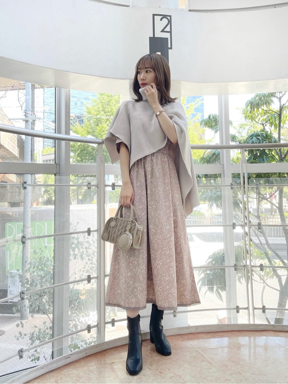 ピンク系のワンピース、ベージュ系のニット/セーター、ベージュ系のハンドバッグを着用したレディースの秋コーディネートの2枚目の写真