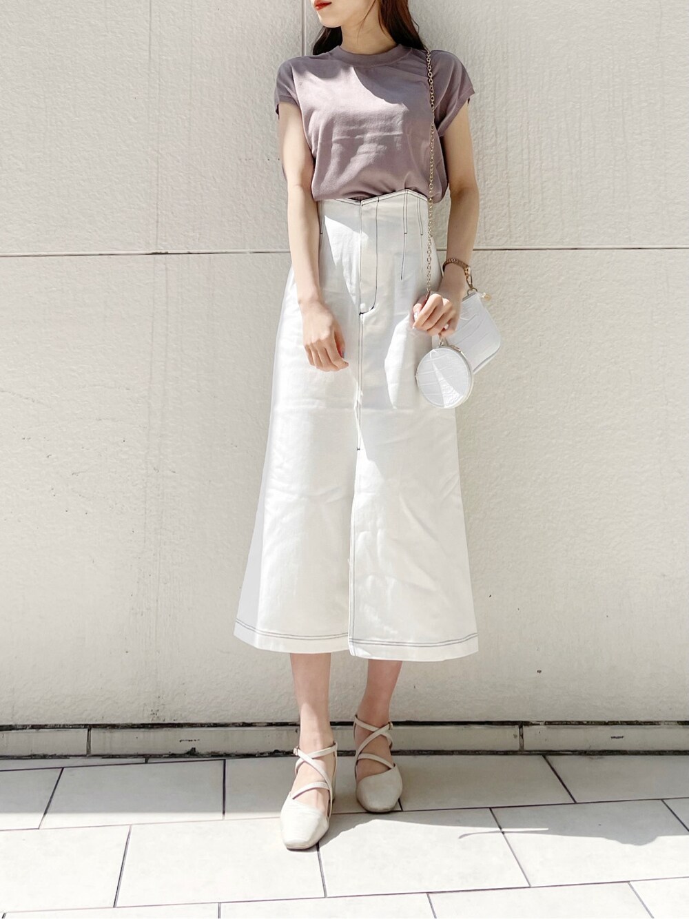 ホワイト系のスカート、ホワイト系のパンプス、ホワイト系のショルダーバッグを着用したレディースの春コーディネートの7枚目の写真