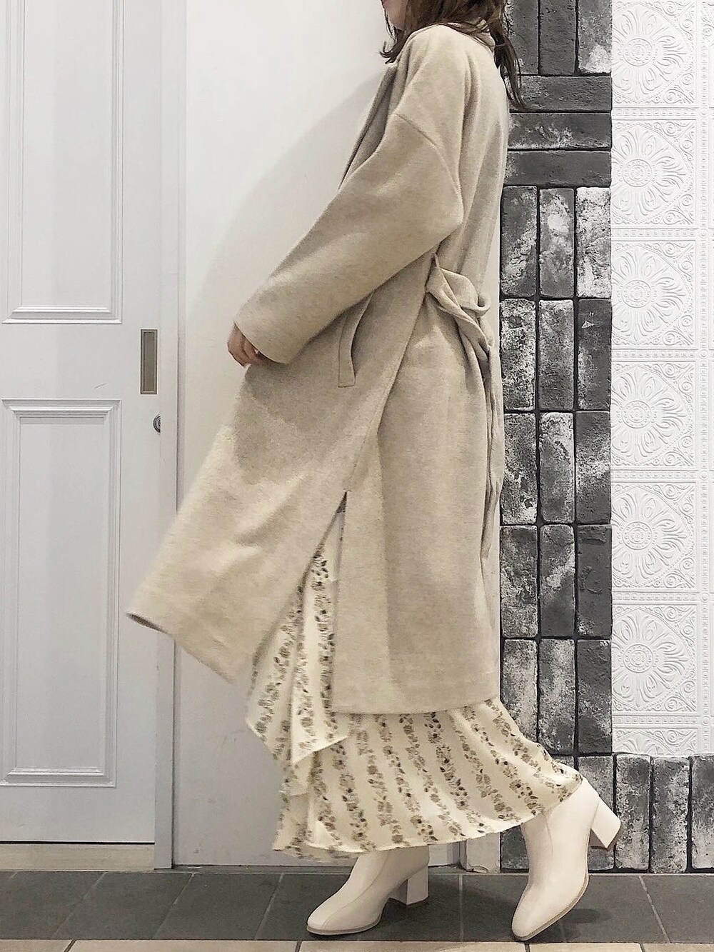 ホワイト系のその他アウター、ホワイト系のニット/セーター、ホワイト系のブーツを着用したレディースの秋コーディネートの2枚目の写真