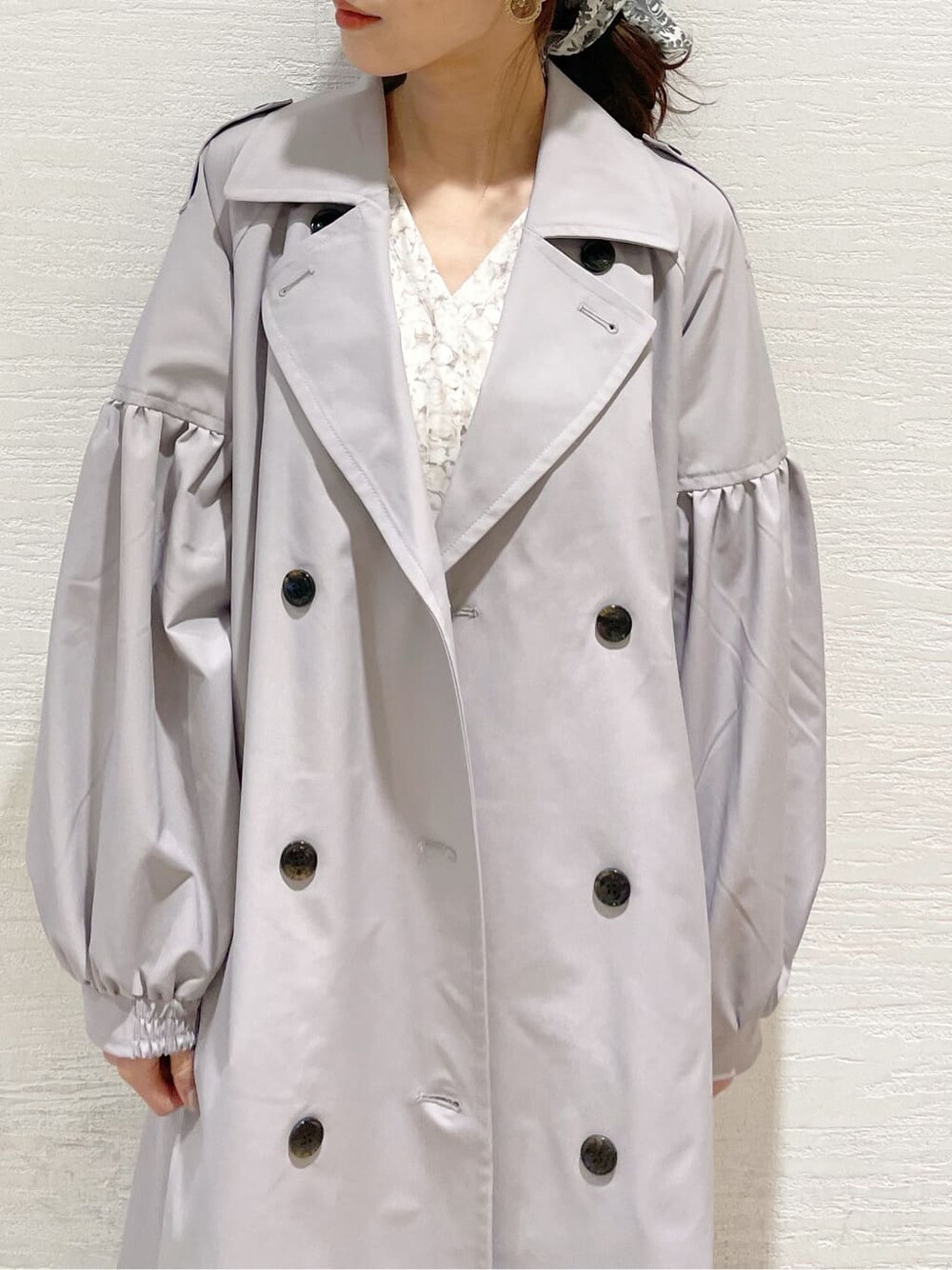 グレー系のトレンチコート、オレンジ系のワンピース、グレー系のニット/セーターを着用したレディースの冬コーディネートの6枚目の写真