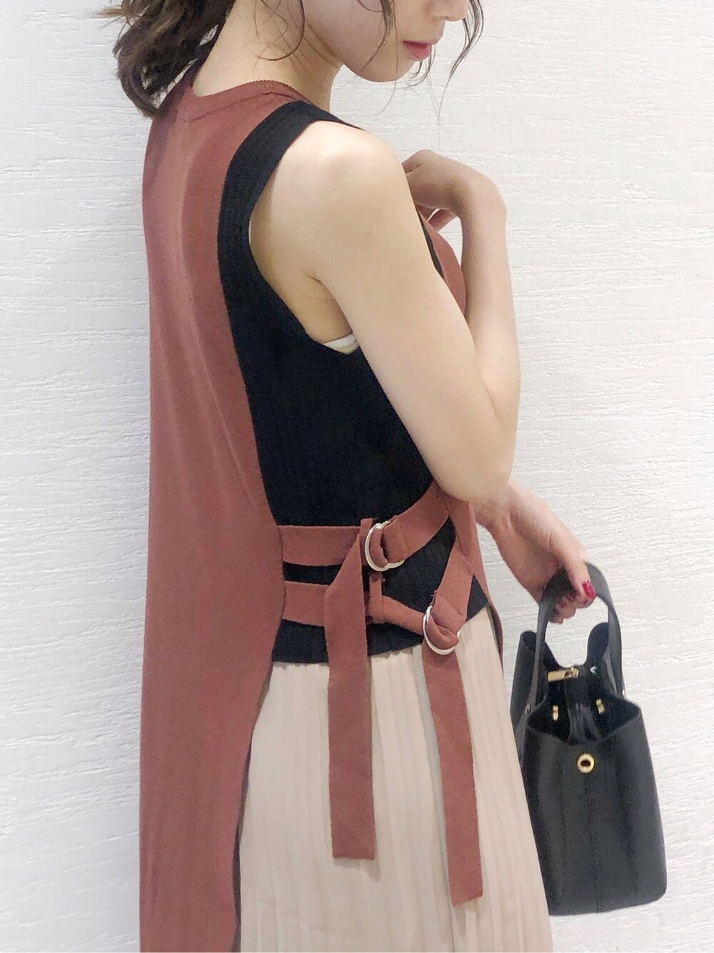 ブラック系のパンプス、ブラック系のハンドバッグ、ブラウン系のワンピースを着用したレディースの夏コーディネートの3枚目の写真