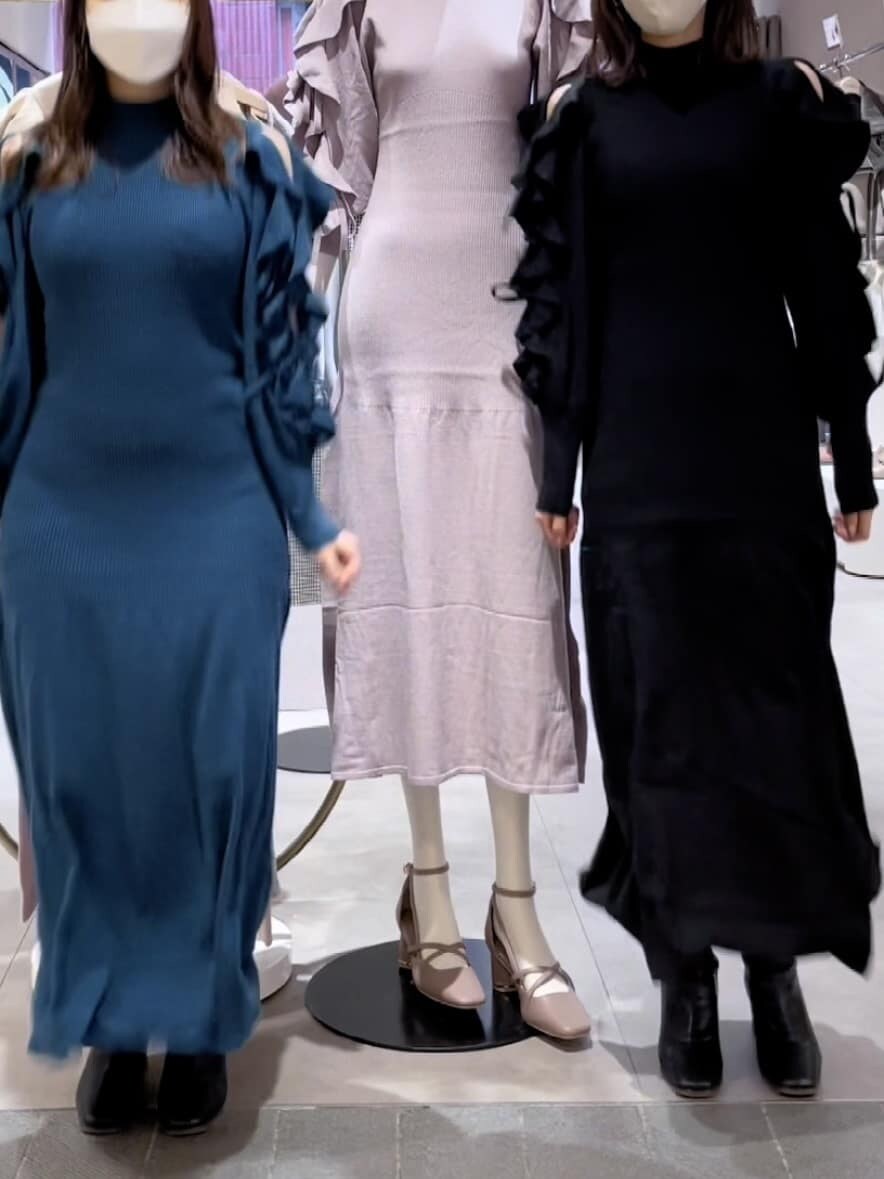 グリーン系のワンピース、ブラック系のブーツ、ホワイト系のブルゾンを着用したレディースの秋コーディネートの4枚目の写真