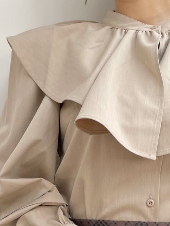 ブラック系のブーツ、ブラウン系のスカート、ベージュ系のシャツ/ブラウスを着用したレディースの冬コーディネートの8枚目の写真