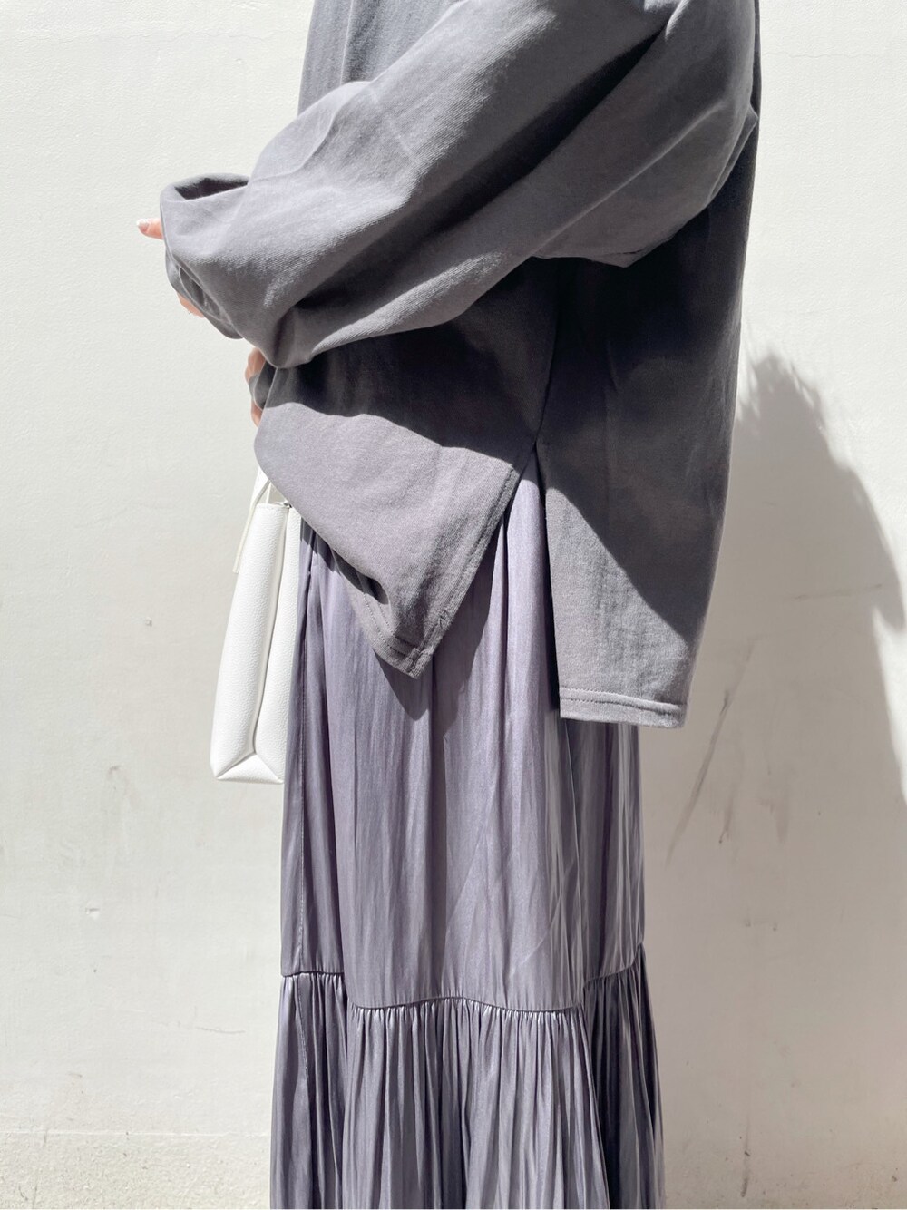 パープル系のスカート、ホワイト系のスニーカー、ホワイト系のハンドバッグを着用したレディースの春コーディネートの7枚目の写真