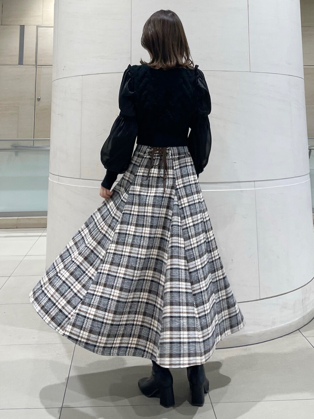 その他のスカート、ブラック系のニット/セーター、ブラック系のブーツを着用したレディースの冬コーディネートの3枚目の写真