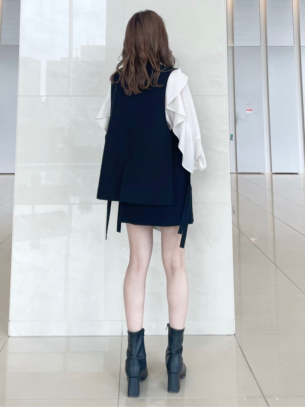 ホワイト系のシャツ/ブラウス、ブラック系のベスト、ブラック系のスカートを着用したレディースの秋コーディネートの4枚目の写真