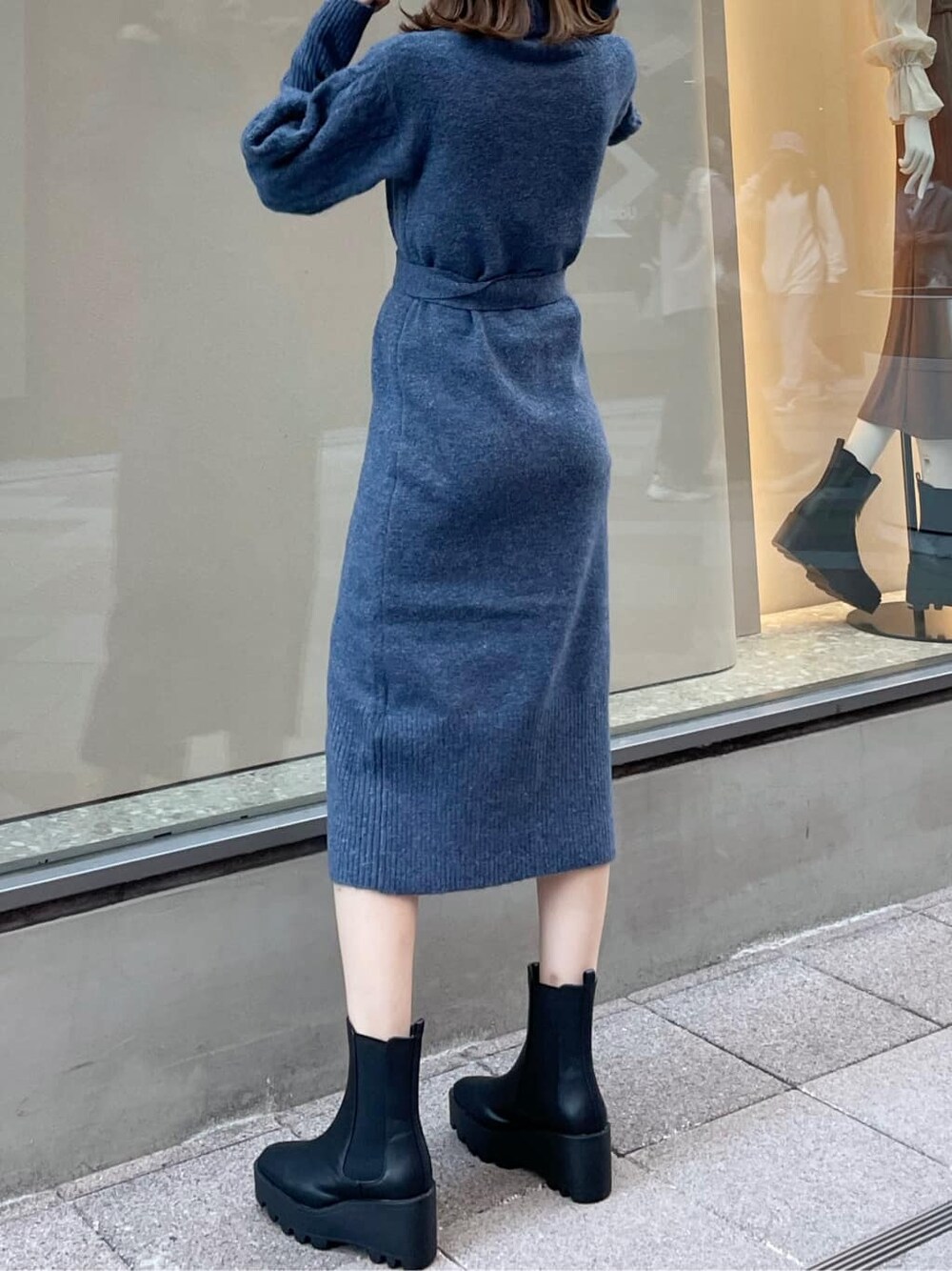 ブルー系のワンピース、ブラック系のブーツを着用したレディースの秋コーディネートの2枚目の写真