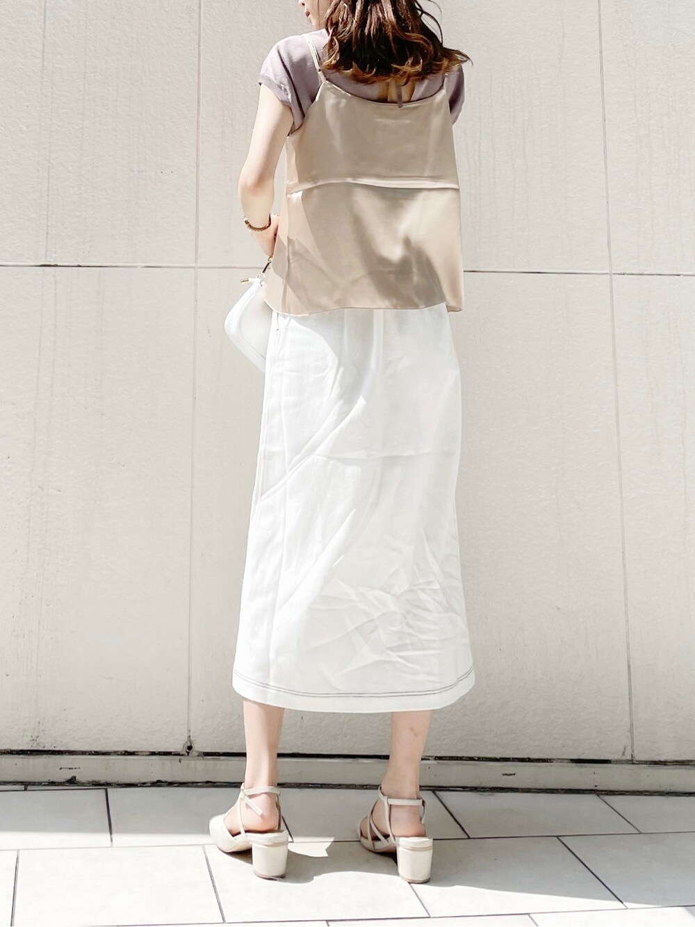 ホワイト系のスカート、ホワイト系のパンプス、ホワイト系のショルダーバッグを着用したレディースの春コーディネートの3枚目の写真