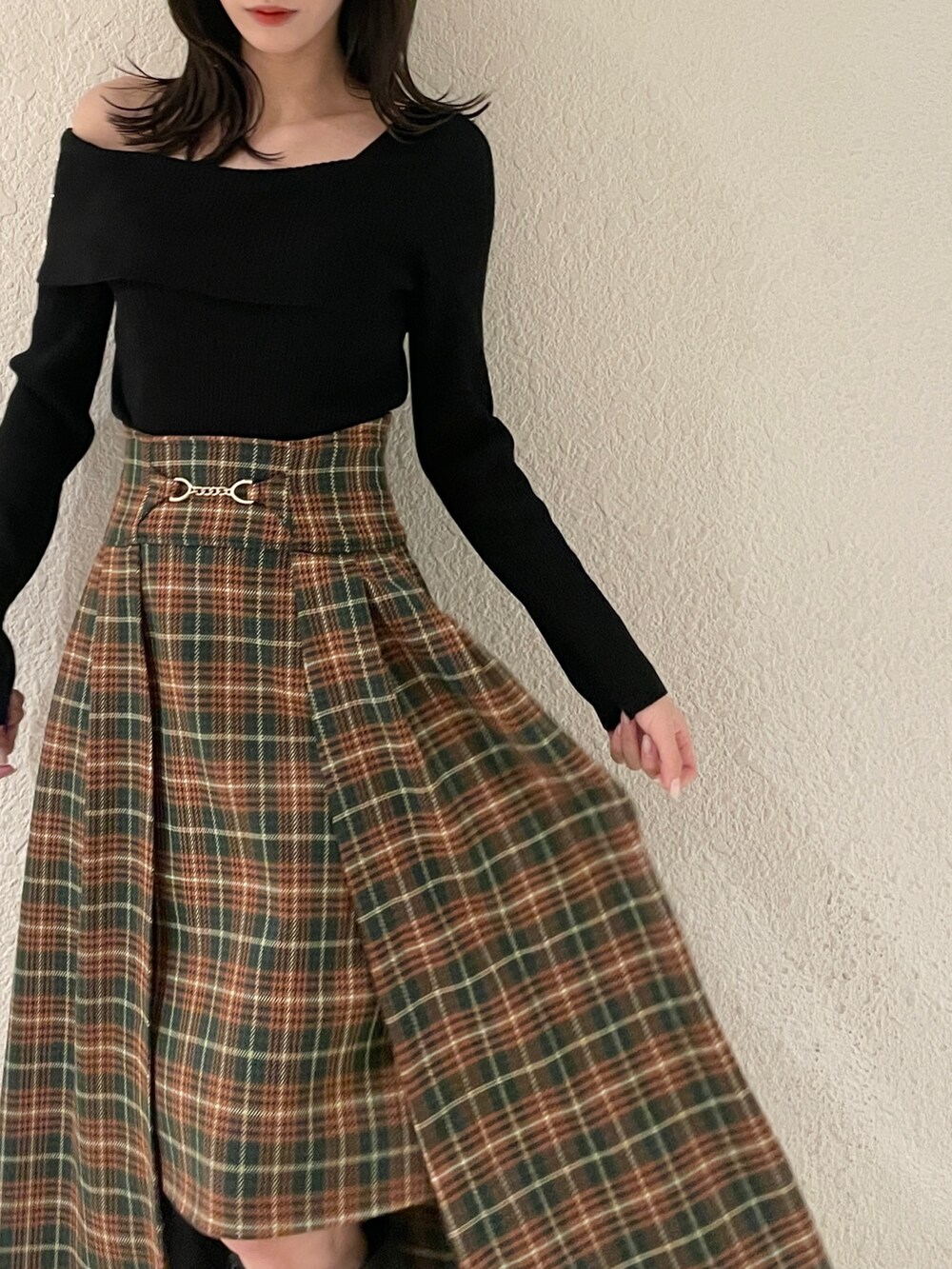 ブラック系のニット/セーター、ブラック系のブーツ、グリーン系のスカートを着用したレディースの秋コーディネートの5枚目の写真