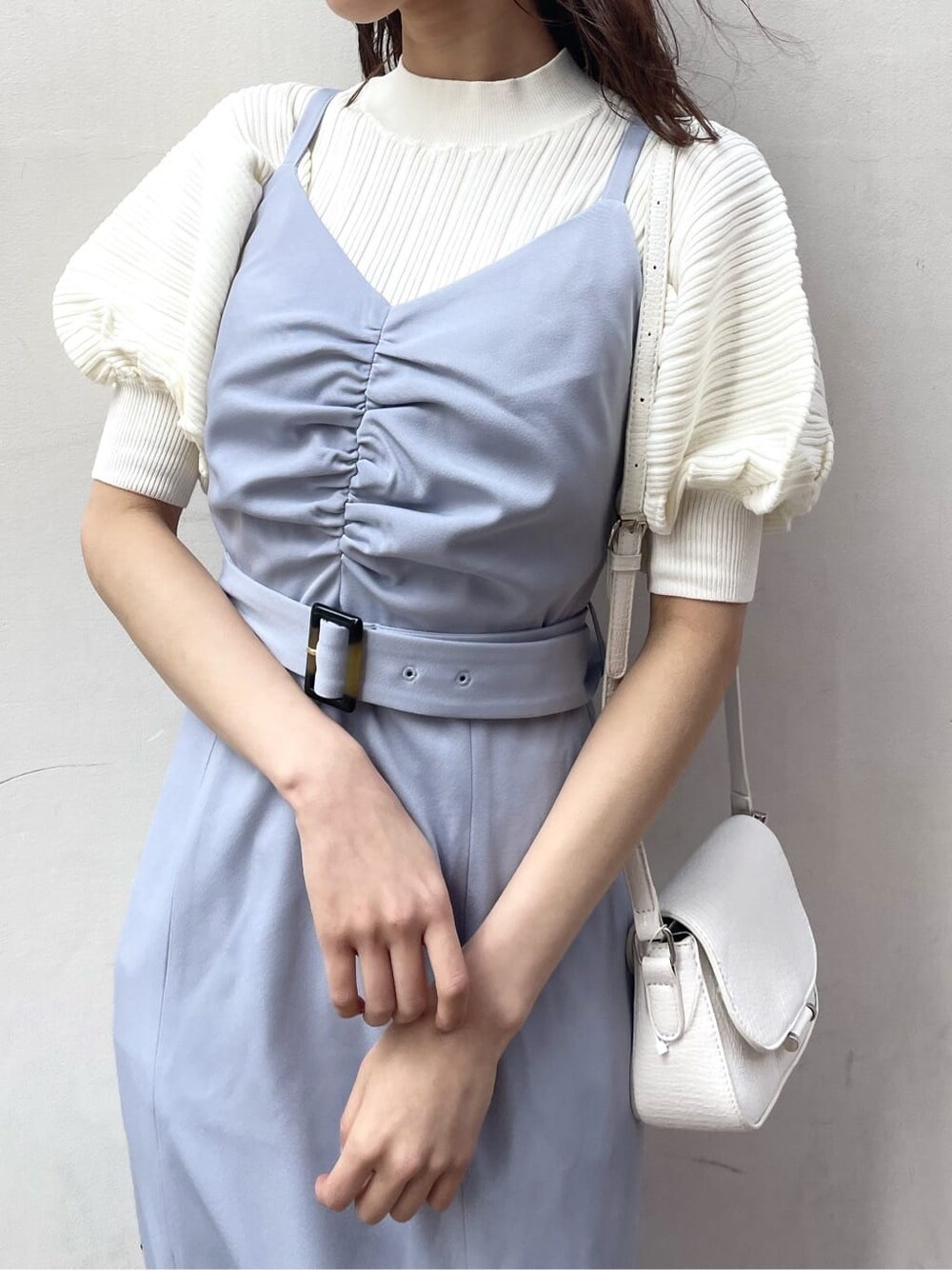 ブルー系のワンピース、ホワイト系のニット/セーター、ホワイト系のパンプスを着用したレディースの春コーディネートの4枚目の写真