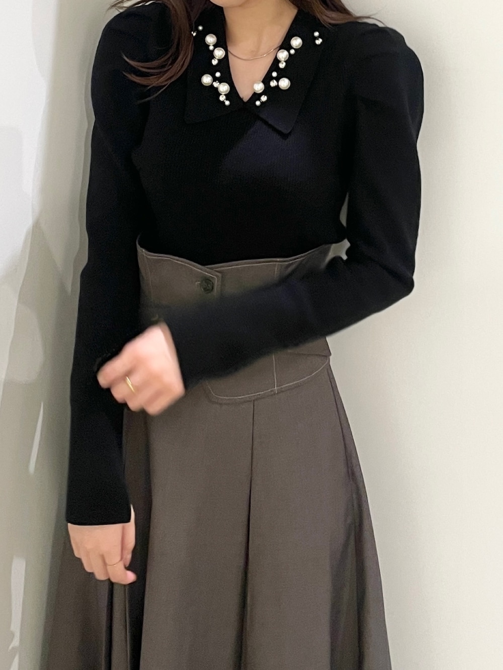 ブラック系のニット/セーター、ブラック系のローファー、グレー系のスカートを着用したレディースの秋コーディネートの3枚目の写真