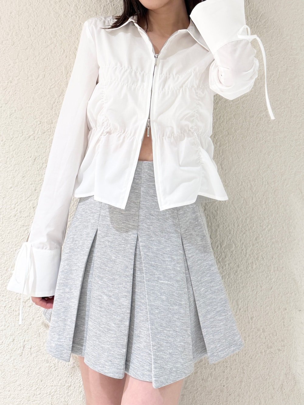 グレー系のスカート、ブラック系のハンドバッグ、ホワイト系のシャツ/ブラウスを着用したレディースの春コーディネートの3枚目の写真