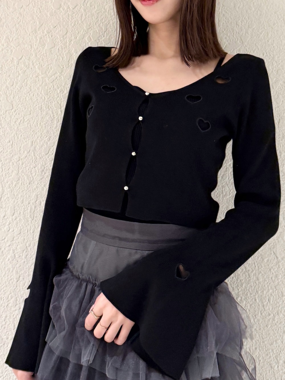 グレー系のスカート、ブラック系のニット/セーター、ブラック系のブーツを着用したレディースの春コーディネートの4枚目の写真