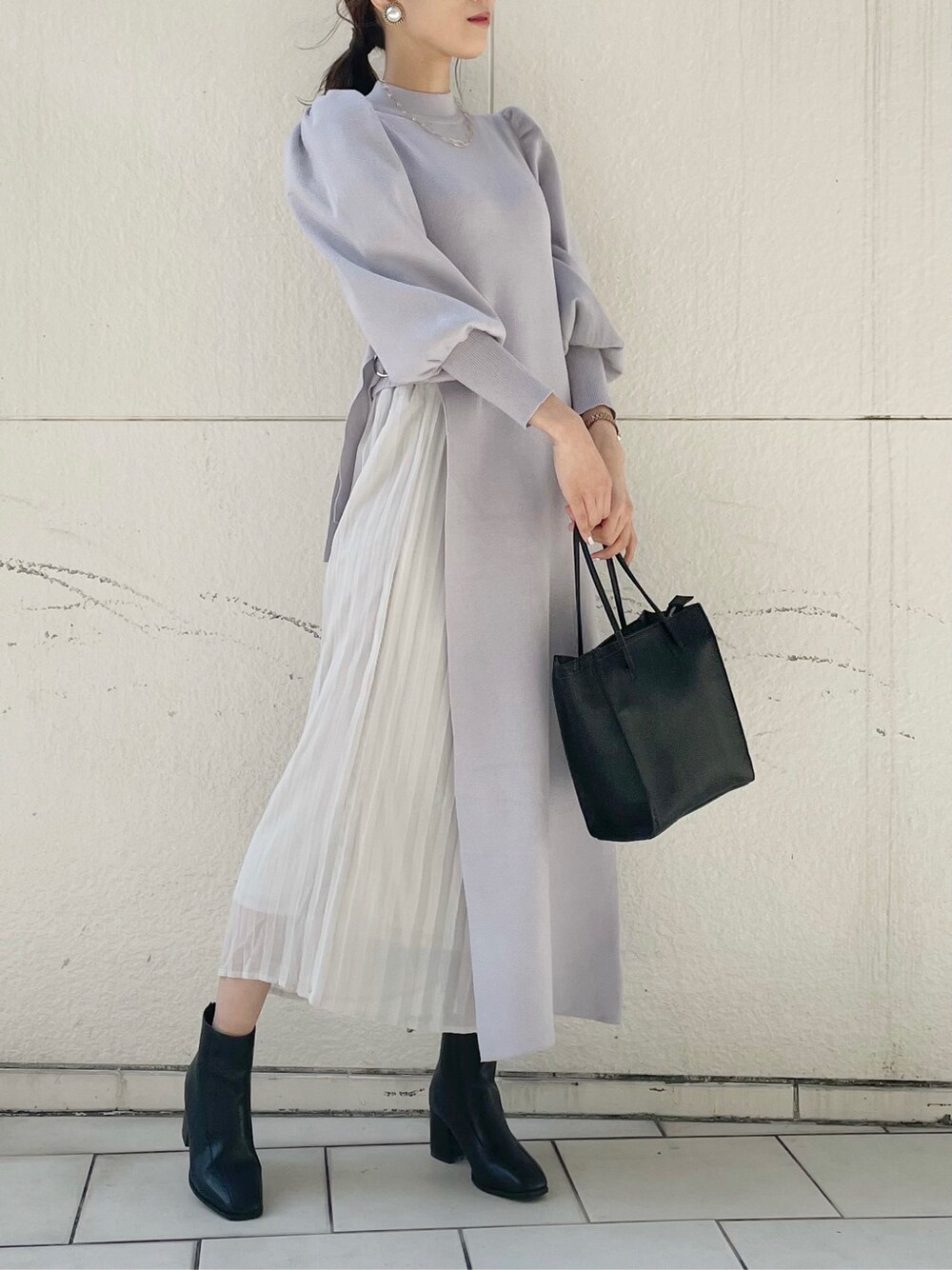 ブラック系のブーツ、ブラック系のハンドバッグ、グレー系のワンピースを着用したレディースの冬コーディネートの4枚目の写真