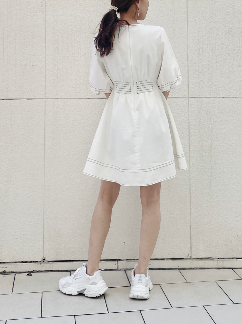 ホワイト系のスニーカー、ホワイト系のワンピースを着用したレディースの春コーディネートの3枚目の写真