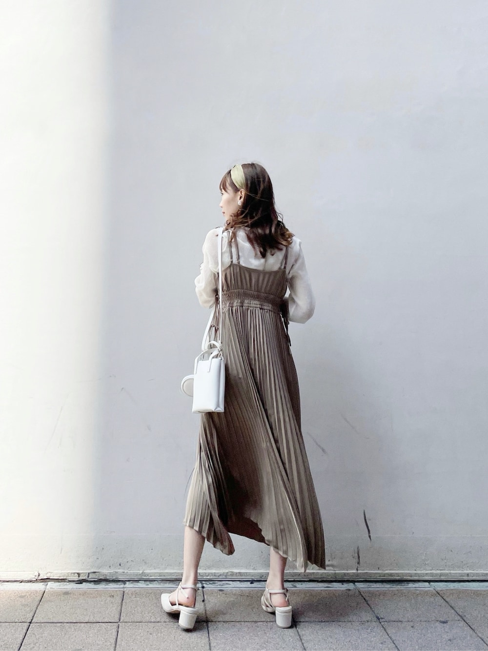 ベージュ系のワンピース、ベージュ系のTシャツ/カットソー、ホワイト系のパンプスを着用したレディースの春コーディネートの2枚目の写真