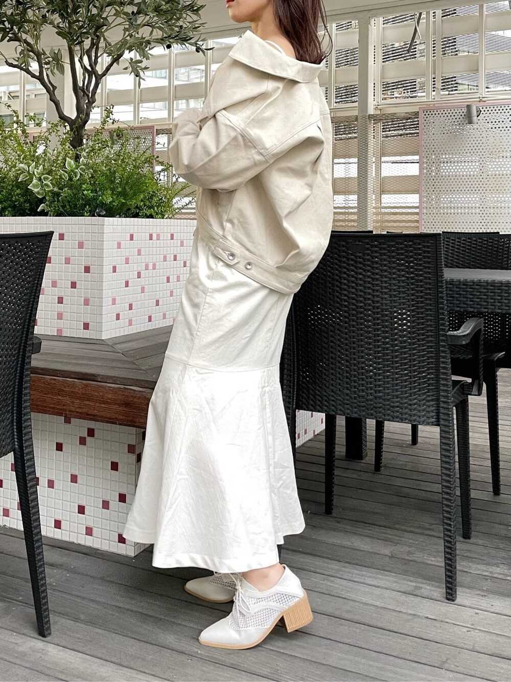 ベージュ系のデニムジャケット、ホワイト系のワンピース、ホワイト系のローファーを着用したレディースの春コーディネートの2枚目の写真