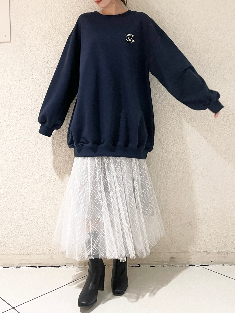 グレー系のスカート、ブラック系のブーツ、ブルー系のTシャツ/カットソーを着用したレディースの冬コーディネートの2枚目の写真