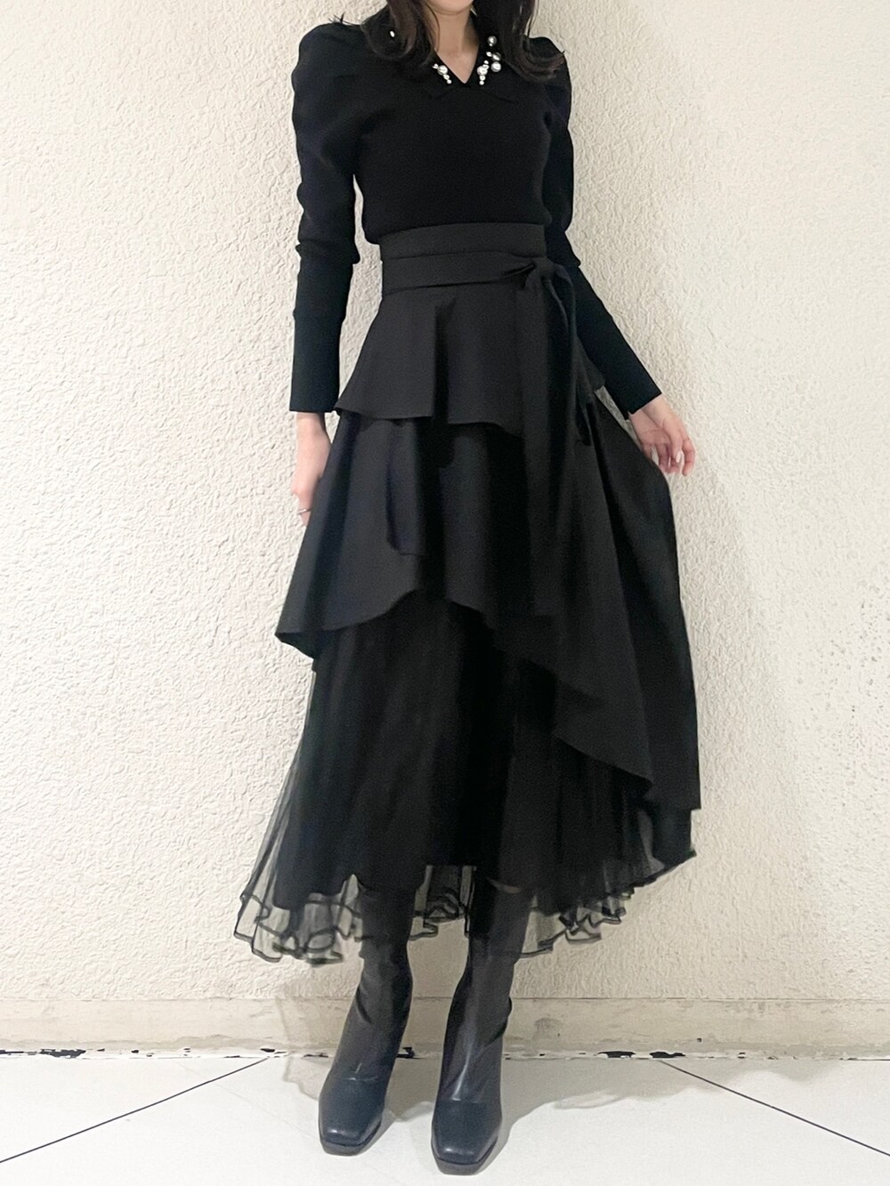 ブラック系のニット/セーター、ブラック系のブーツ、ブラック系のスカートを着用したレディースの冬コーディネートの4枚目の写真