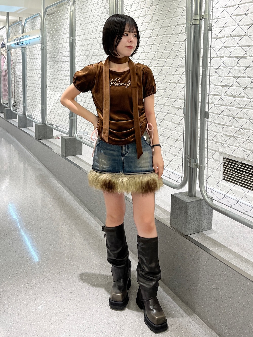 ブラウン系のTシャツ/カットソー、ブルー系のスカート、ブラック系のブーツを着用したレディースの夏コーディネートの2枚目の写真