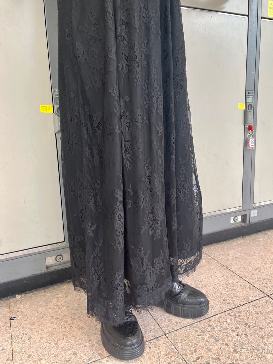 ブラック系のブーツ、ブラック系のワンピース、シルバー系のブレスレットを着用したレディースの春コーディネートの7枚目の写真