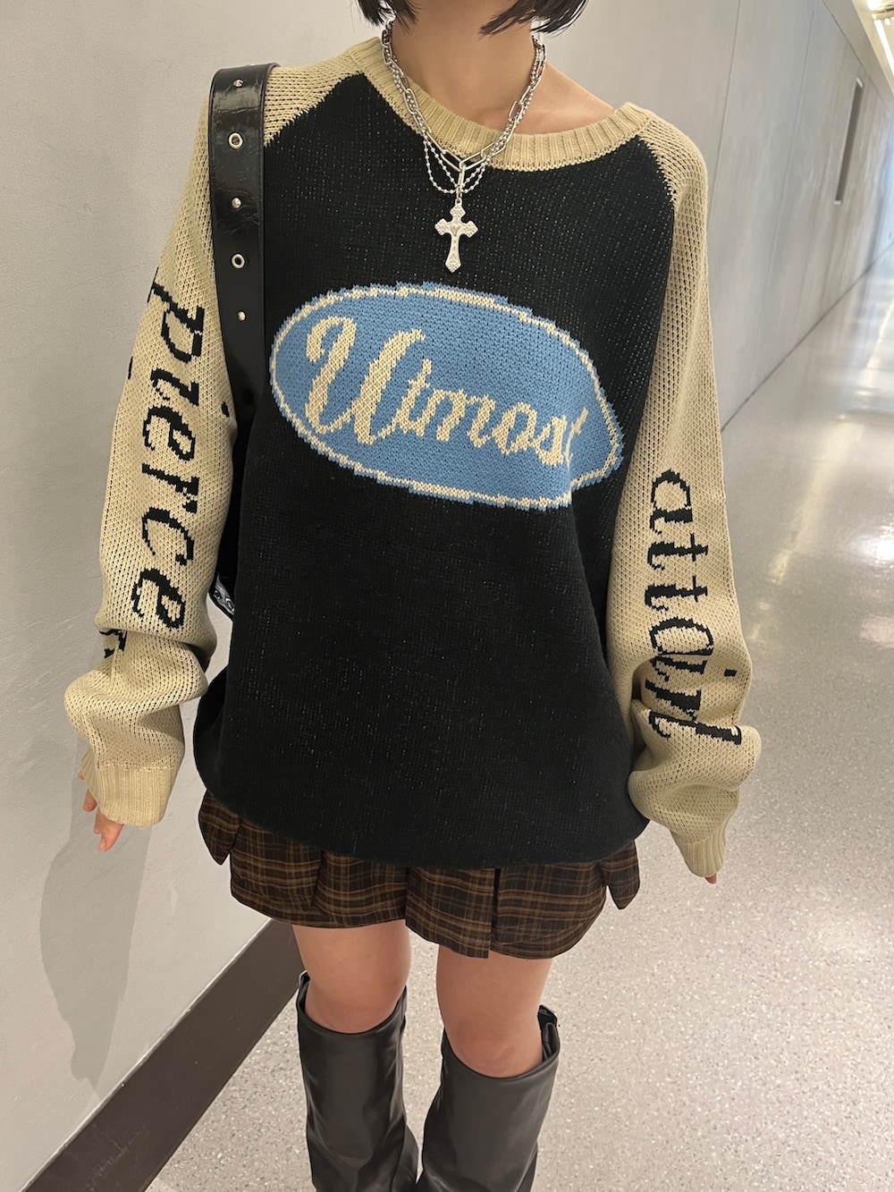 ブラック系のニット/セーター、ブラウン系のスカート、ブラック系のショルダーバッグを着用したレディースの秋コーディネートの7枚目の写真