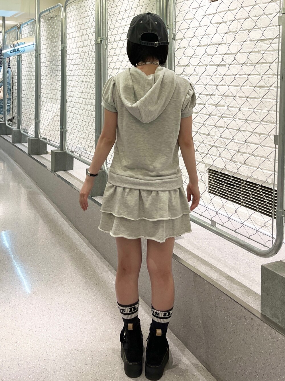 グレー系のワンピース、ブラック系のキャップ、ブラック系のチョーカーを着用したレディースの夏コーディネートの4枚目の写真