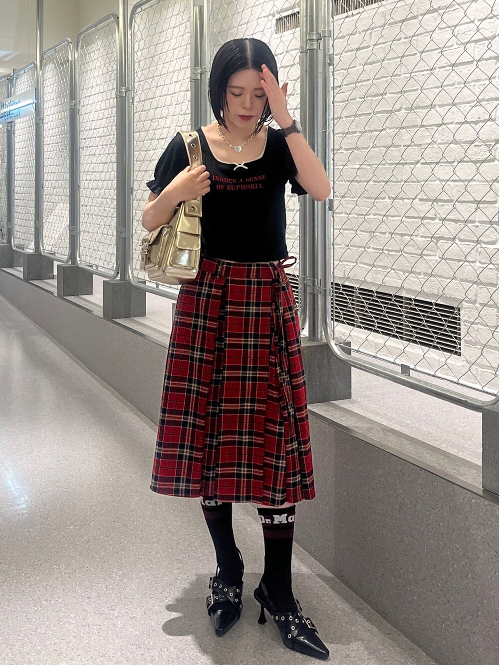 ブラック系のTシャツ/カットソー、レッド系のスカート、ブラック系のパンプスを着用したレディースの夏コーディネートの2枚目の写真