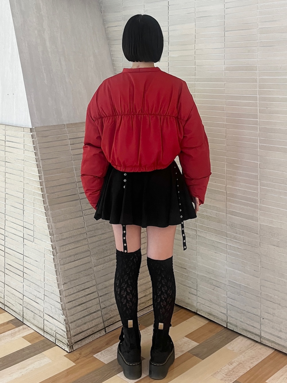 レッド系のブルゾン、ブラック系のスカートを着用したレディースの冬コーディネートの4枚目の写真