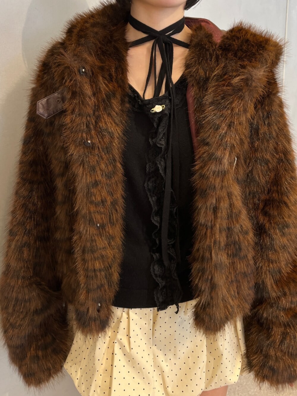 ホワイト系のスカート、ブラウン系のブルゾン、ブラック系のニット/セーターを着用したレディースの秋コーディネートの6枚目の写真