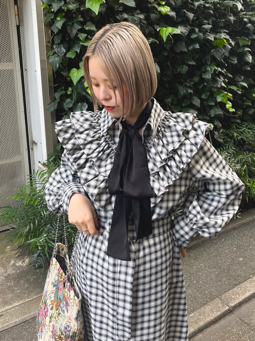 ブラック系のワンピース、ホワイト系のトートバッグ、ブラック系のブーツを着用したレディースの冬コーディネートの6枚目の写真