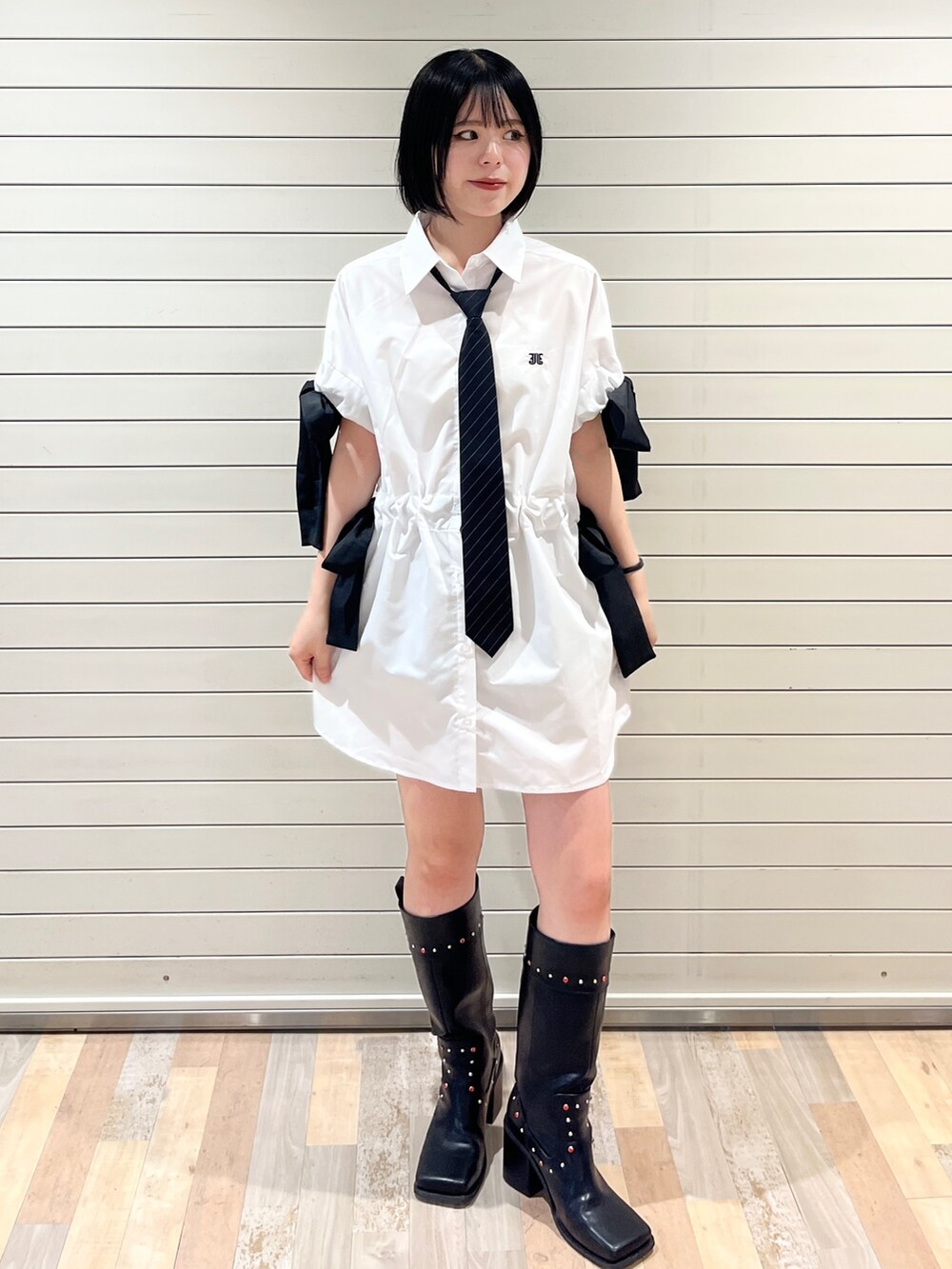 ブラック系のネクタイ、ブラック系のブーツ、ホワイト系のシャツ/ブラウスを着用したレディースの夏コーディネートの2枚目の写真