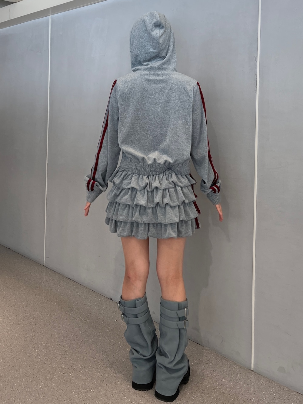 グレー系のパーカー、グレー系のスカート、ブルー系のブーツを着用したレディースの夏コーディネートの5枚目の写真