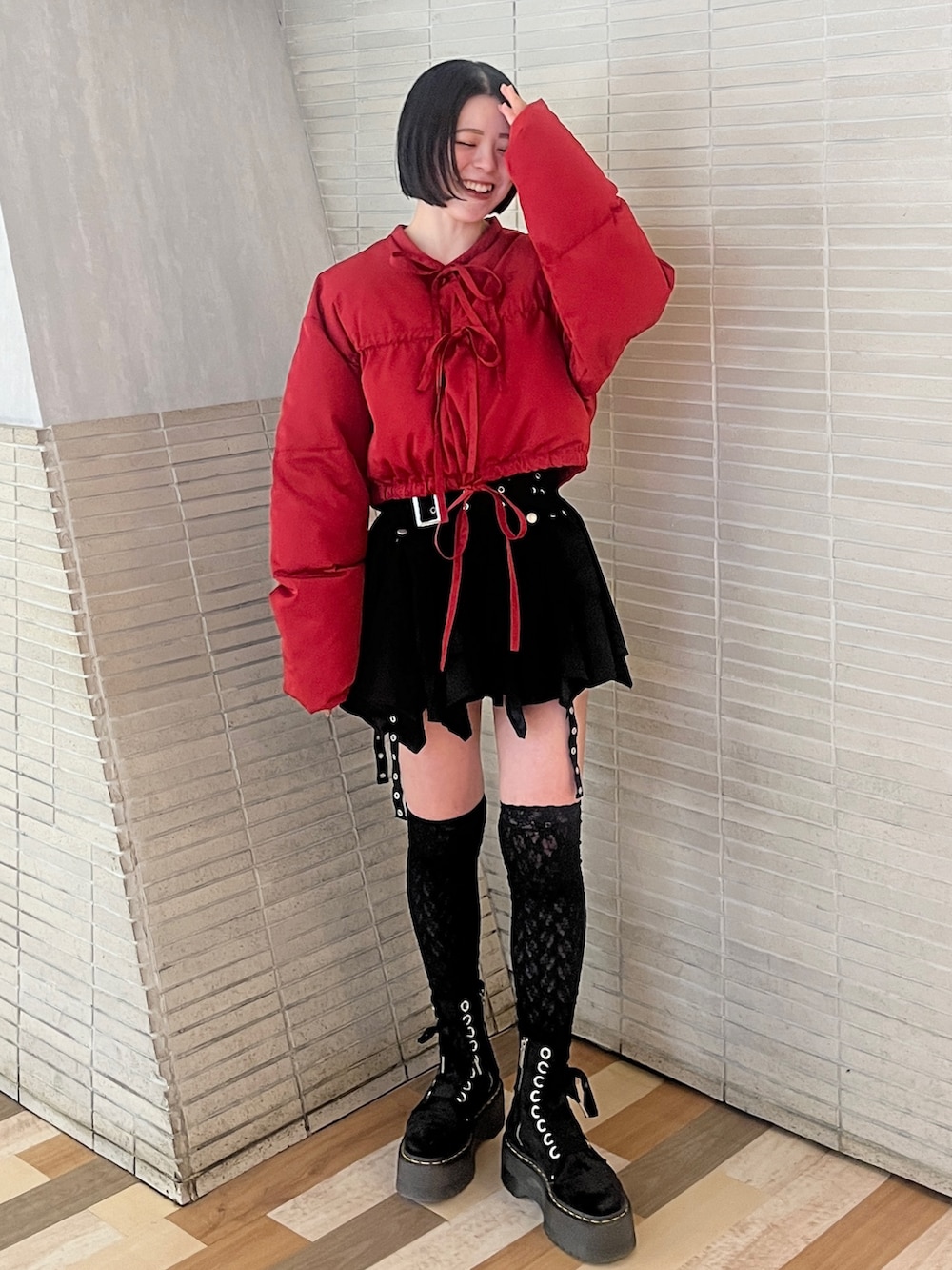 レッド系のブルゾン、ブラック系のスカートを着用したレディースの冬コーディネートの2枚目の写真