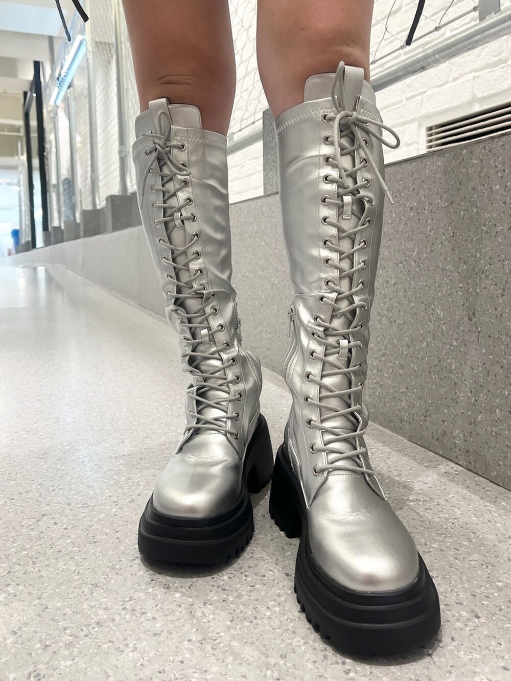 シルバー系のブーツ、ブルー系のカーディガン/ボレロ、ブラック系のハンドバッグを着用したレディースの夏コーディネートの9枚目の写真