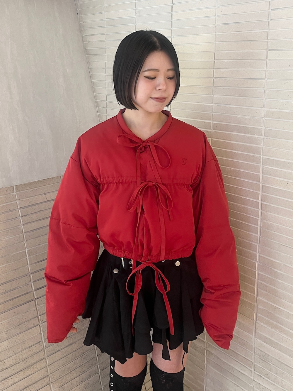 レッド系のブルゾン、ブラック系のスカートを着用したレディースの冬コーディネートの5枚目の写真