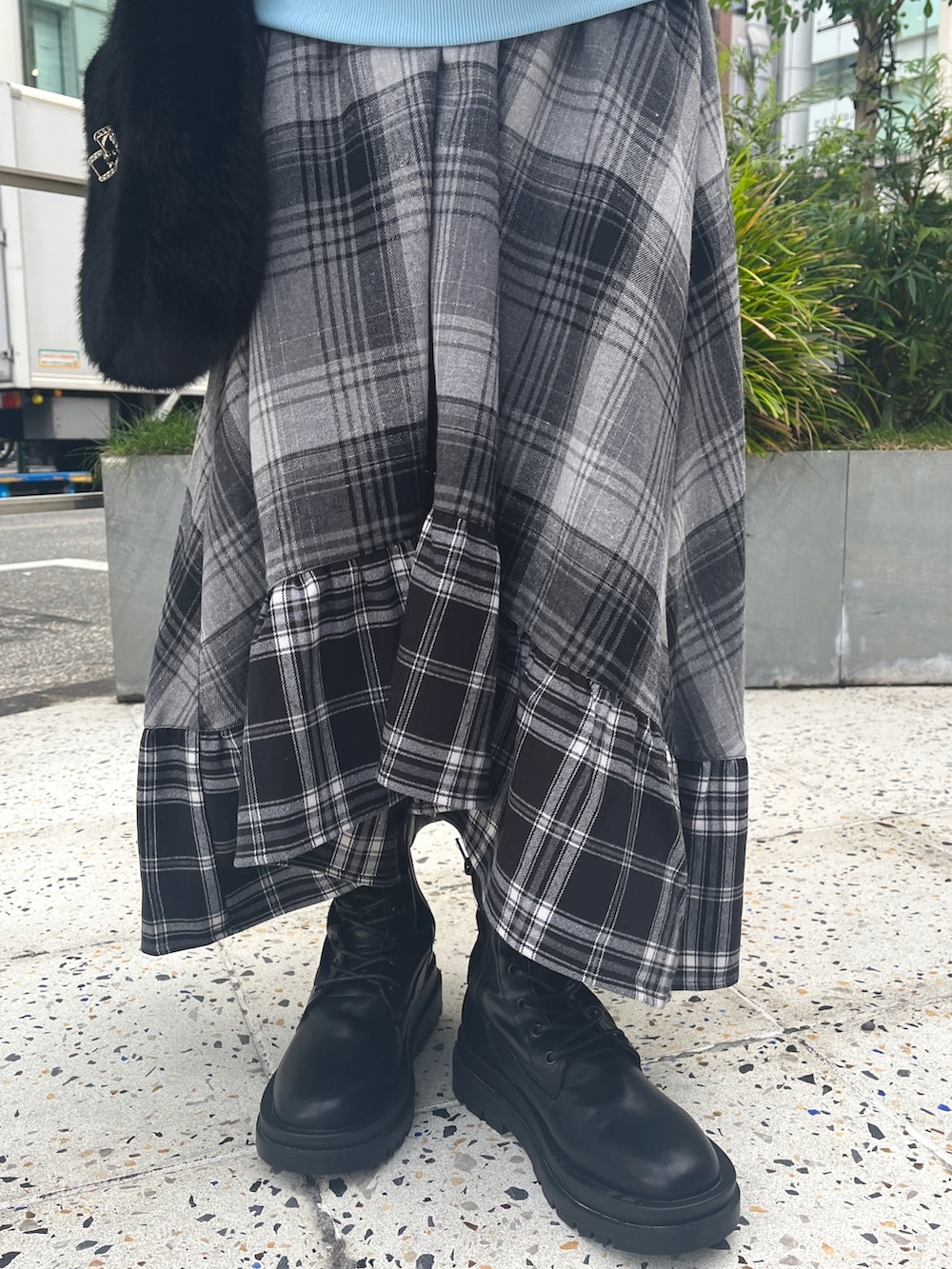 ブラック系のハンドバッグ、ブルー系のニット/セーター、グレー系のスカートを着用したレディースの冬コーディネートの8枚目の写真