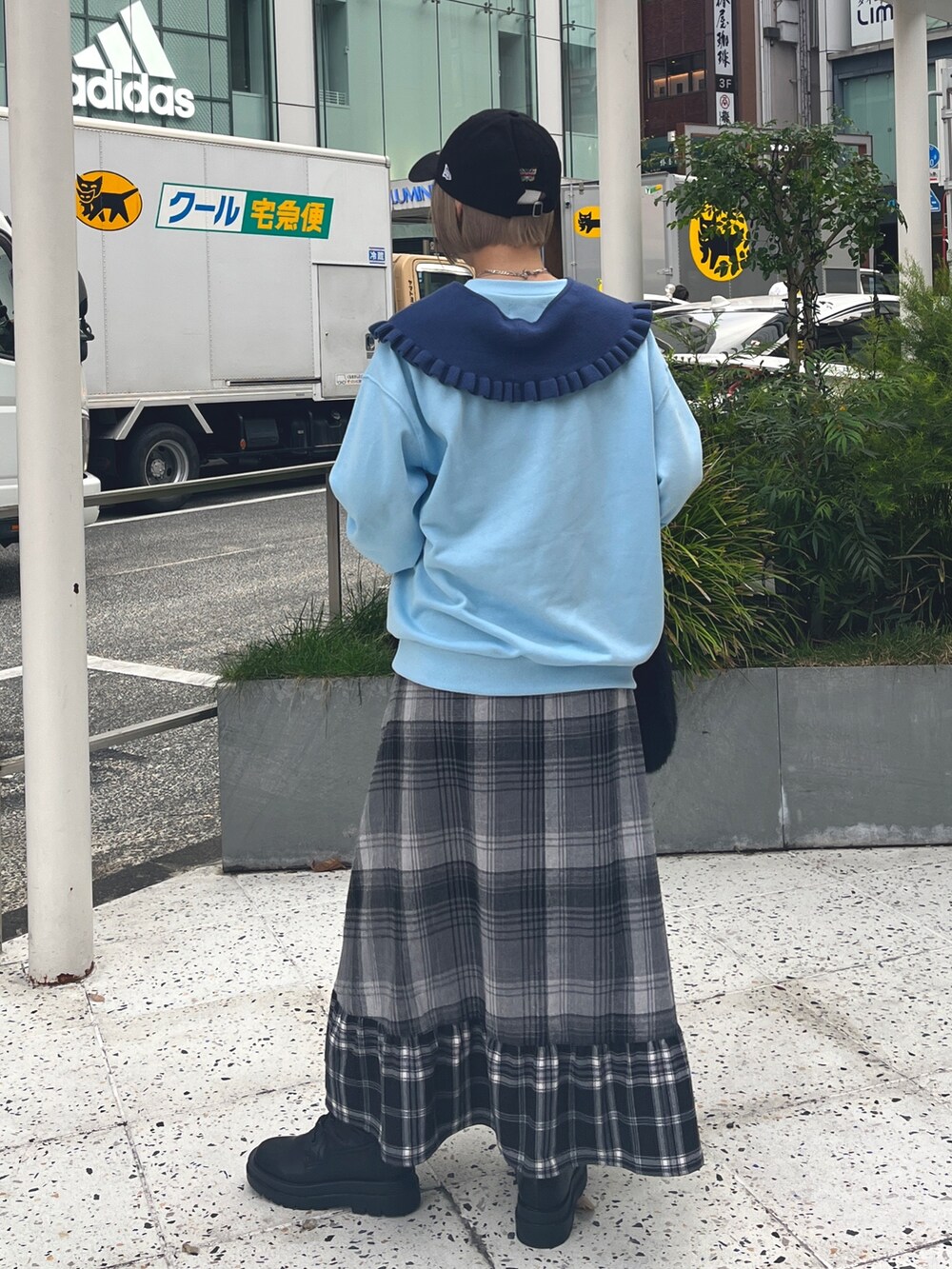 ブラック系のハンドバッグ、ブルー系のニット/セーター、グレー系のスカートを着用したレディースの冬コーディネートの4枚目の写真