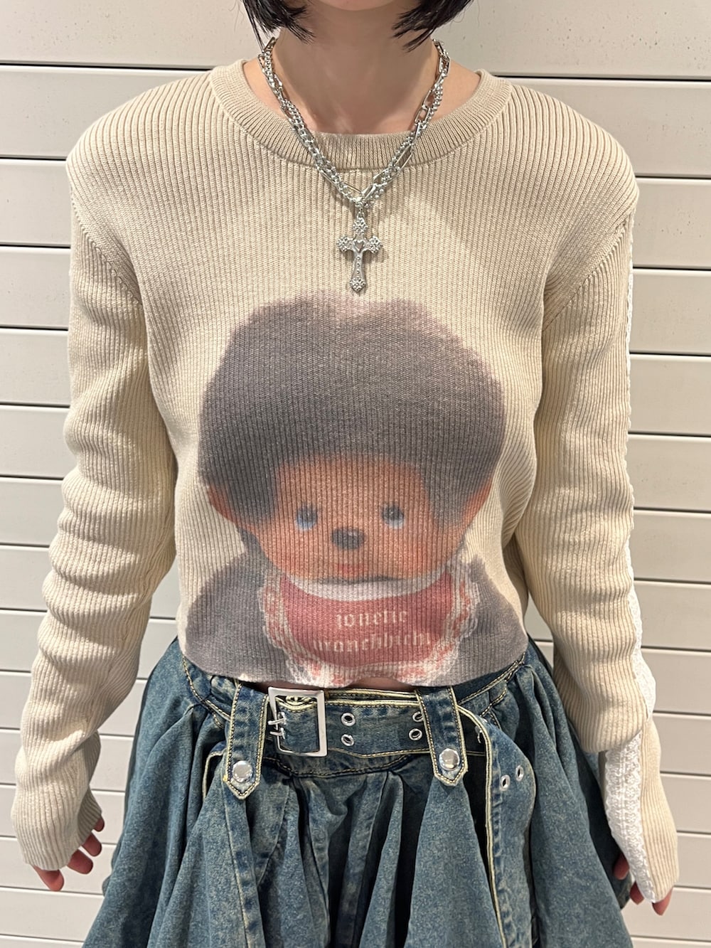 ホワイト系のニット/セーター、ブルー系のデニムスカート、ブラウン系のキャップを着用したレディースの秋コーディネートの6枚目の写真