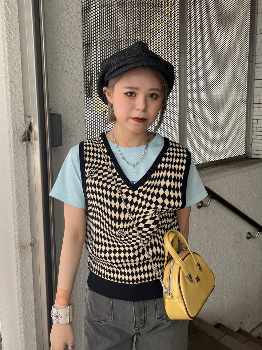 ブラック系のデニムパンツ、ブラック系のニット/セーター、イエロー系のボストンバッグを着用したレディースの夏コーディネートの5枚目の写真