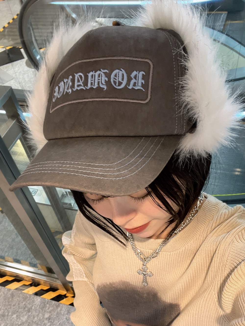 ホワイト系のニット/セーター、ブルー系のデニムスカート、ブラウン系のキャップを着用したレディースの秋コーディネートの9枚目の写真