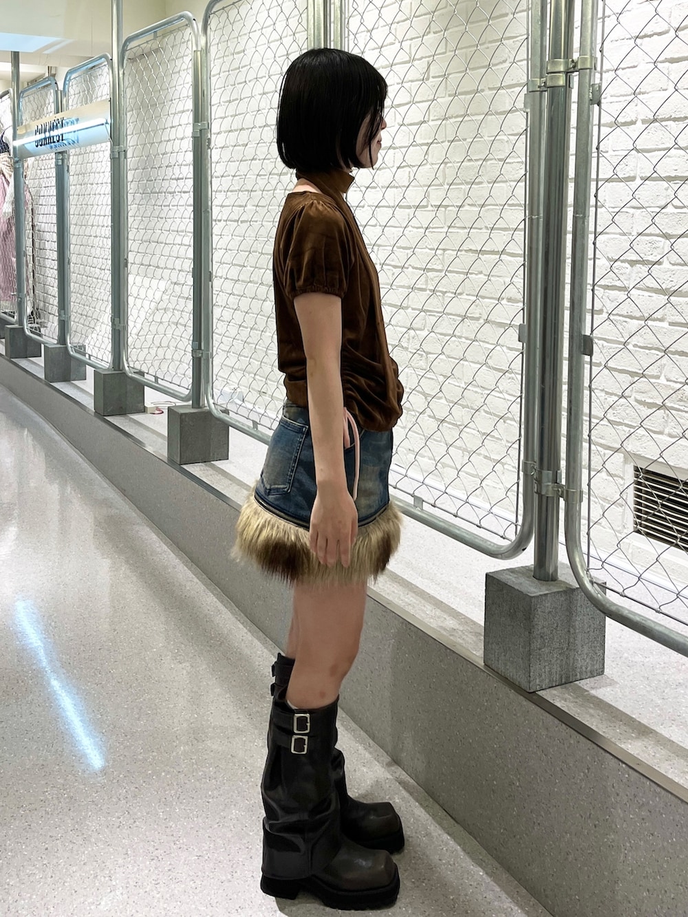 ブラウン系のTシャツ/カットソー、ブルー系のスカート、ブラック系のブーツを着用したレディースの夏コーディネートの3枚目の写真