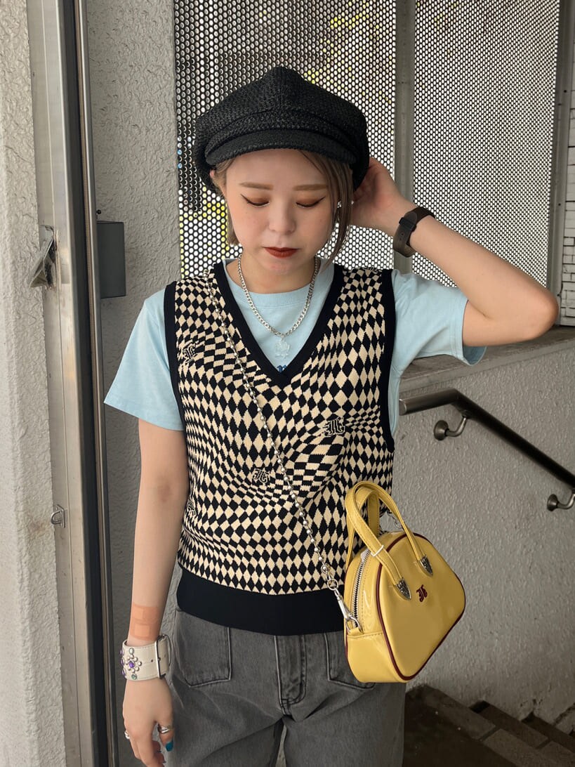 ブラック系のデニムパンツ、ブラック系のニット/セーター、イエロー系のボストンバッグを着用したレディースの夏コーディネートの6枚目の写真