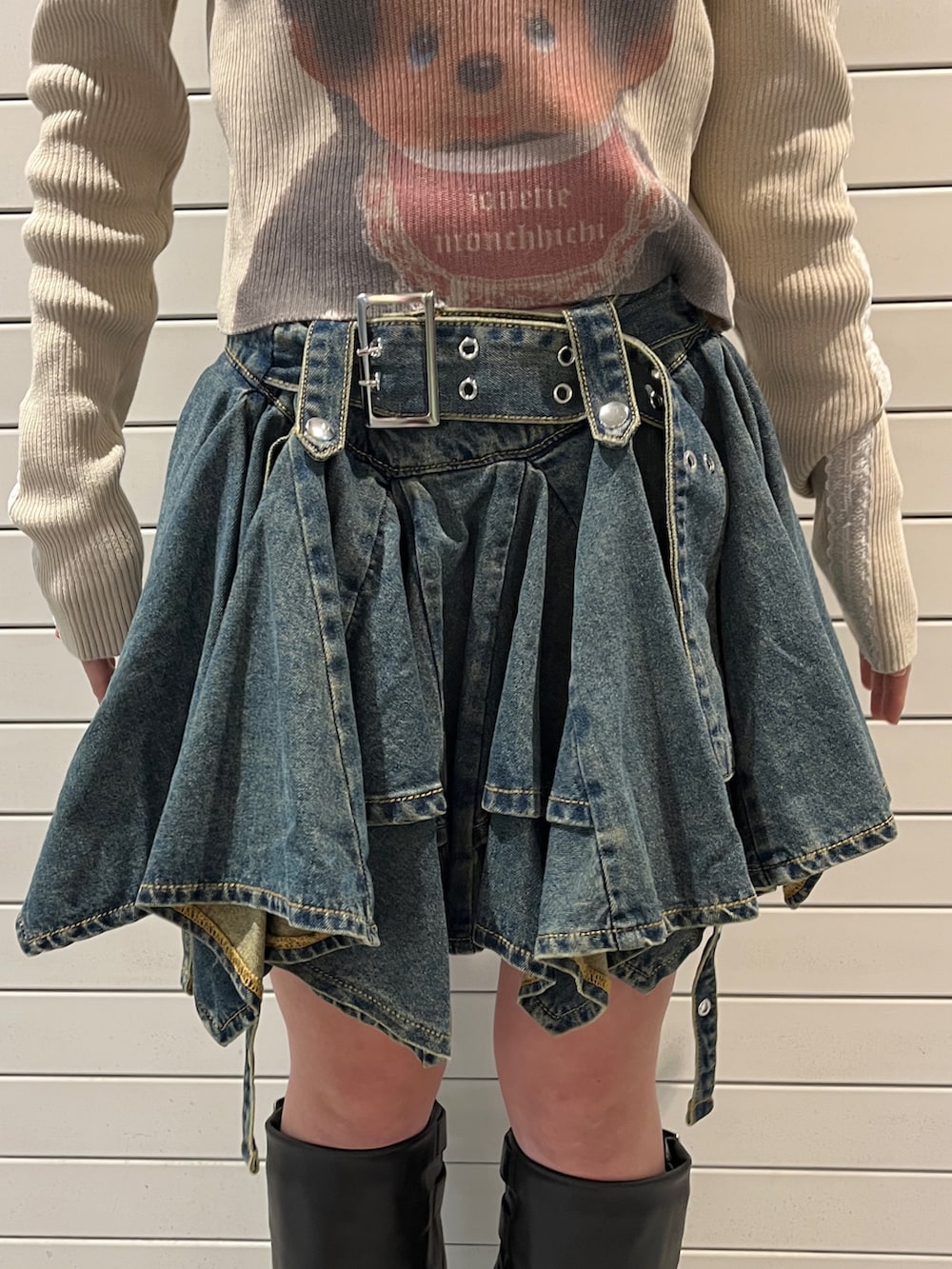 ホワイト系のニット/セーター、ブルー系のデニムスカート、ブラウン系のキャップを着用したレディースの秋コーディネートの8枚目の写真