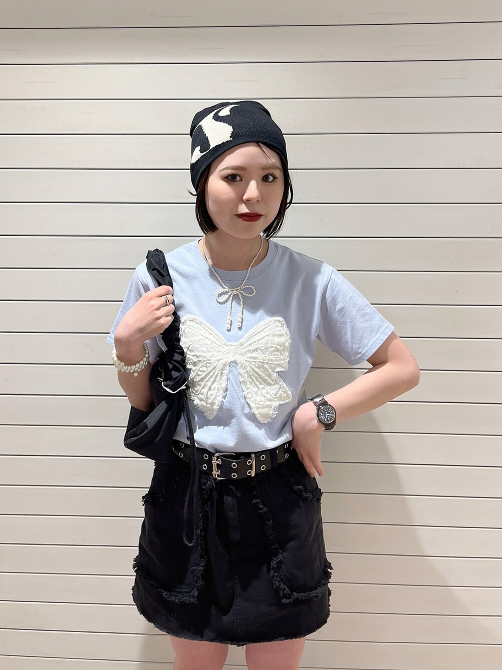 ブラック系のショルダーバッグ、ブラック系のスカート、ブルー系のTシャツ/カットソーを着用したレディースの春コーディネートの5枚目の写真