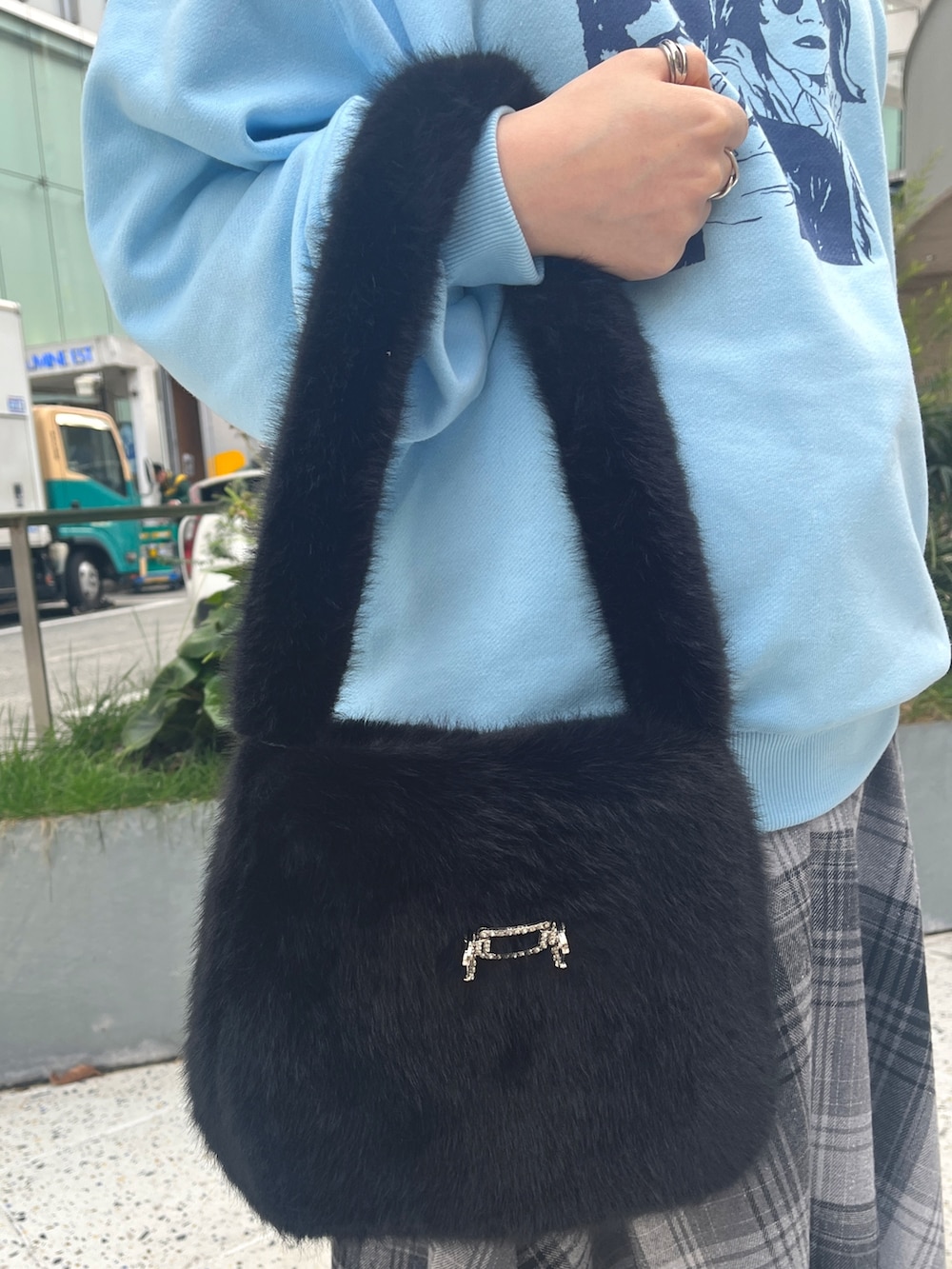 ブラック系のハンドバッグ、ブルー系のニット/セーター、グレー系のスカートを着用したレディースの冬コーディネートの7枚目の写真